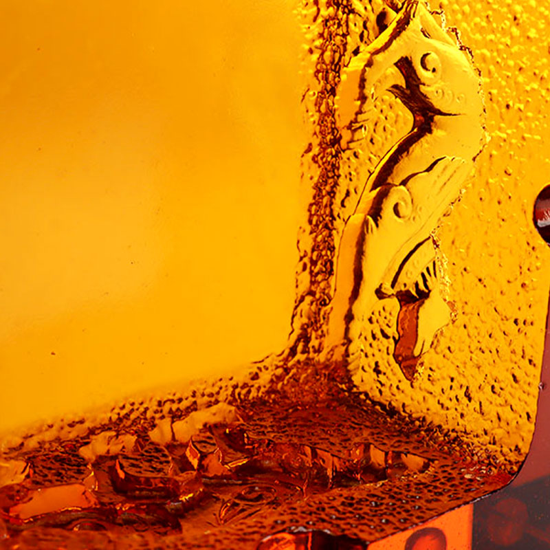 Punainen lasinen tuhkakuppi upeilla kohokuvioiduilla eläinkuvioilla