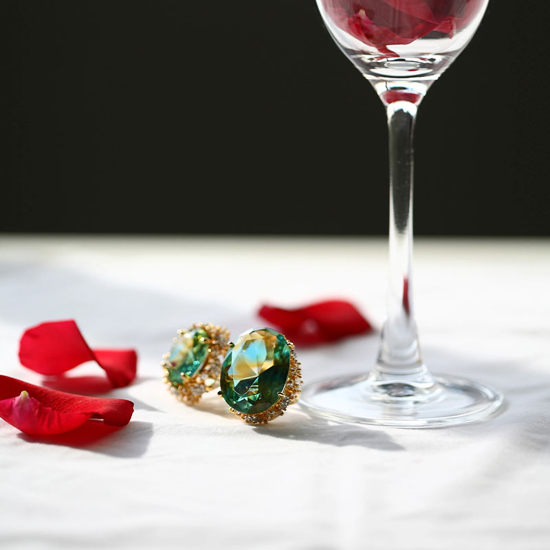 Vihreät lasikorvakorut kultaisilla korvatyynyillä