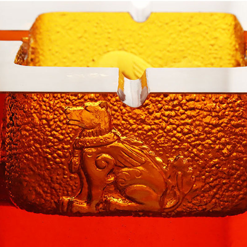 Punainen lasinen tuhkakuppi upeilla kohokuvioiduilla eläinkuvioilla