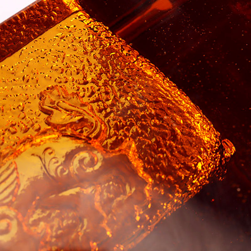 Punainen lasinen tuhkakuppi upeilla kohokuvioiduilla eläinkuvioilla