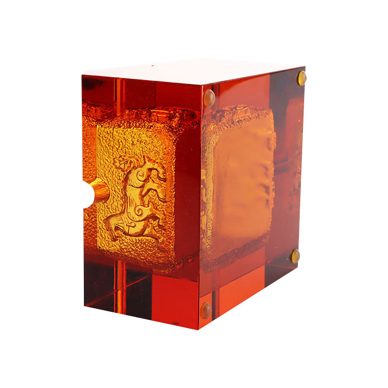 Punainen lasinen tuhkakuppi upeilla kohokuvioiduilla eläinkuvioilla