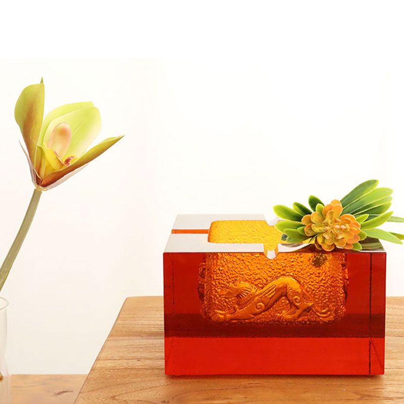 Punainen lasinen tuhkakuppi upeilla kohokuvioiduilla eläinkuvioilla