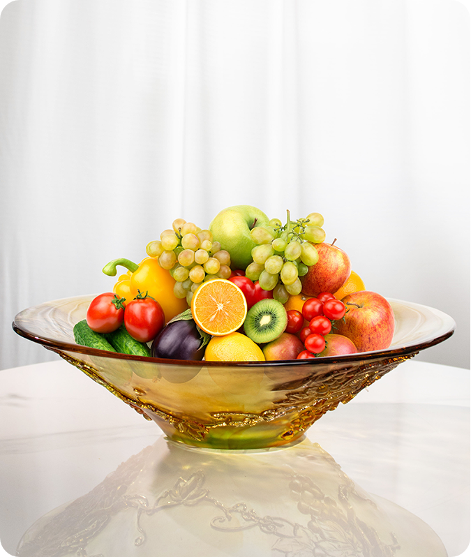 Leveäsuinen lasiastia täynnä hedelmiä